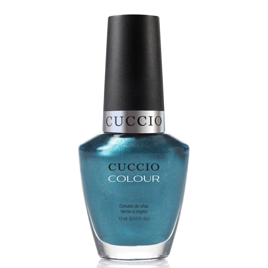 Cuccio nail polish bottle with metallic blue color on a white background
