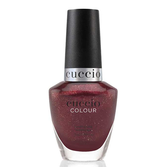 Cuccio nail polish bottle with dark red glittery polish on a white background