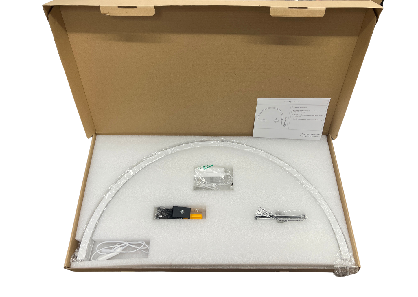 Open cardboard box with contents of half moon led lamp  on a white background
