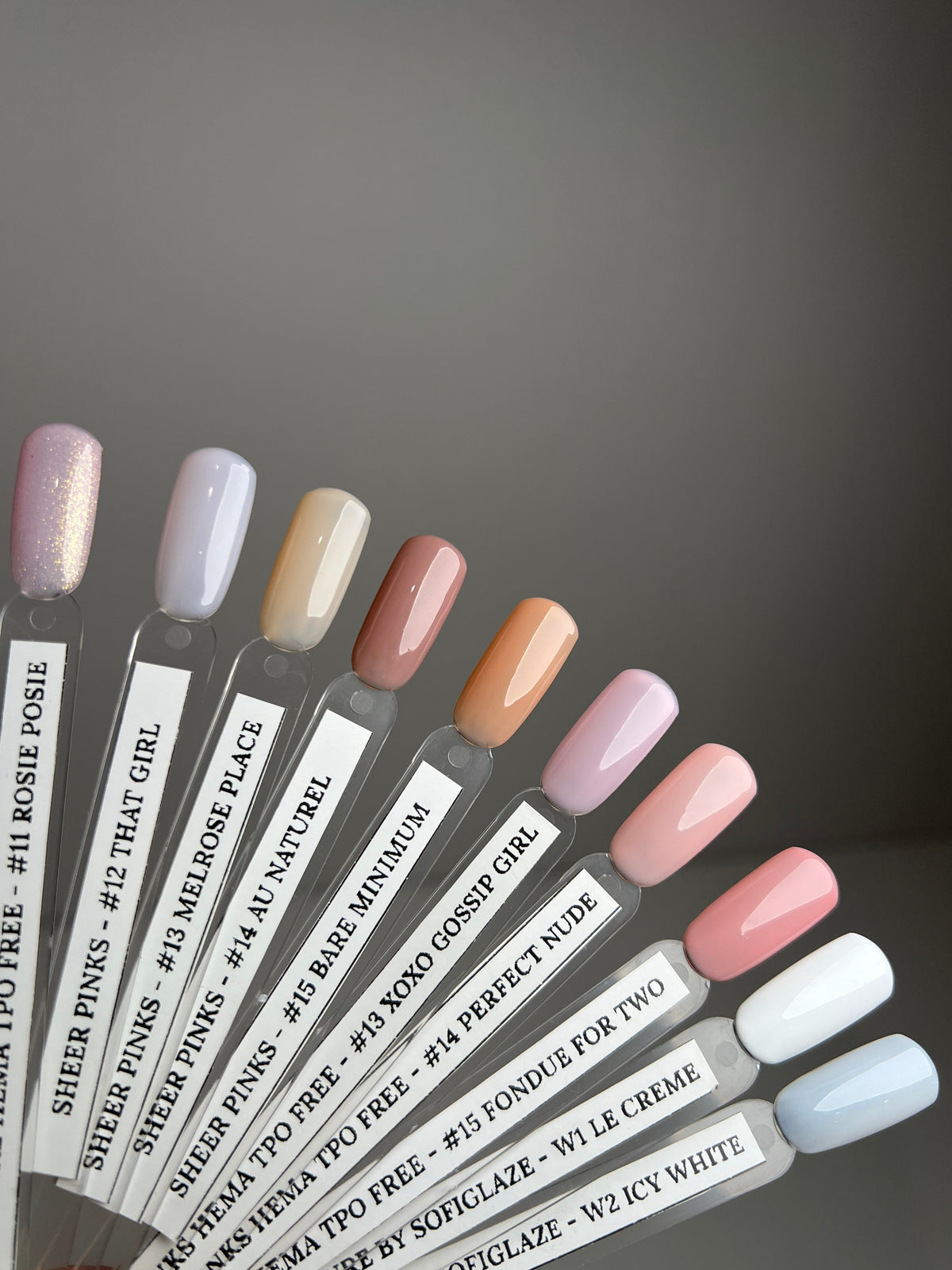 Nail color swatch card with various nail polish colors on a gray background