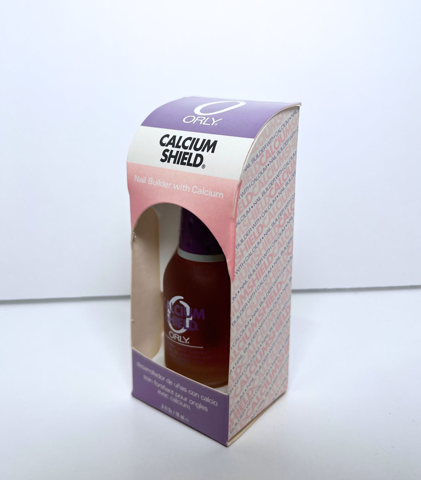 nail polish bottle inside purple and pink colored paper box on a white background