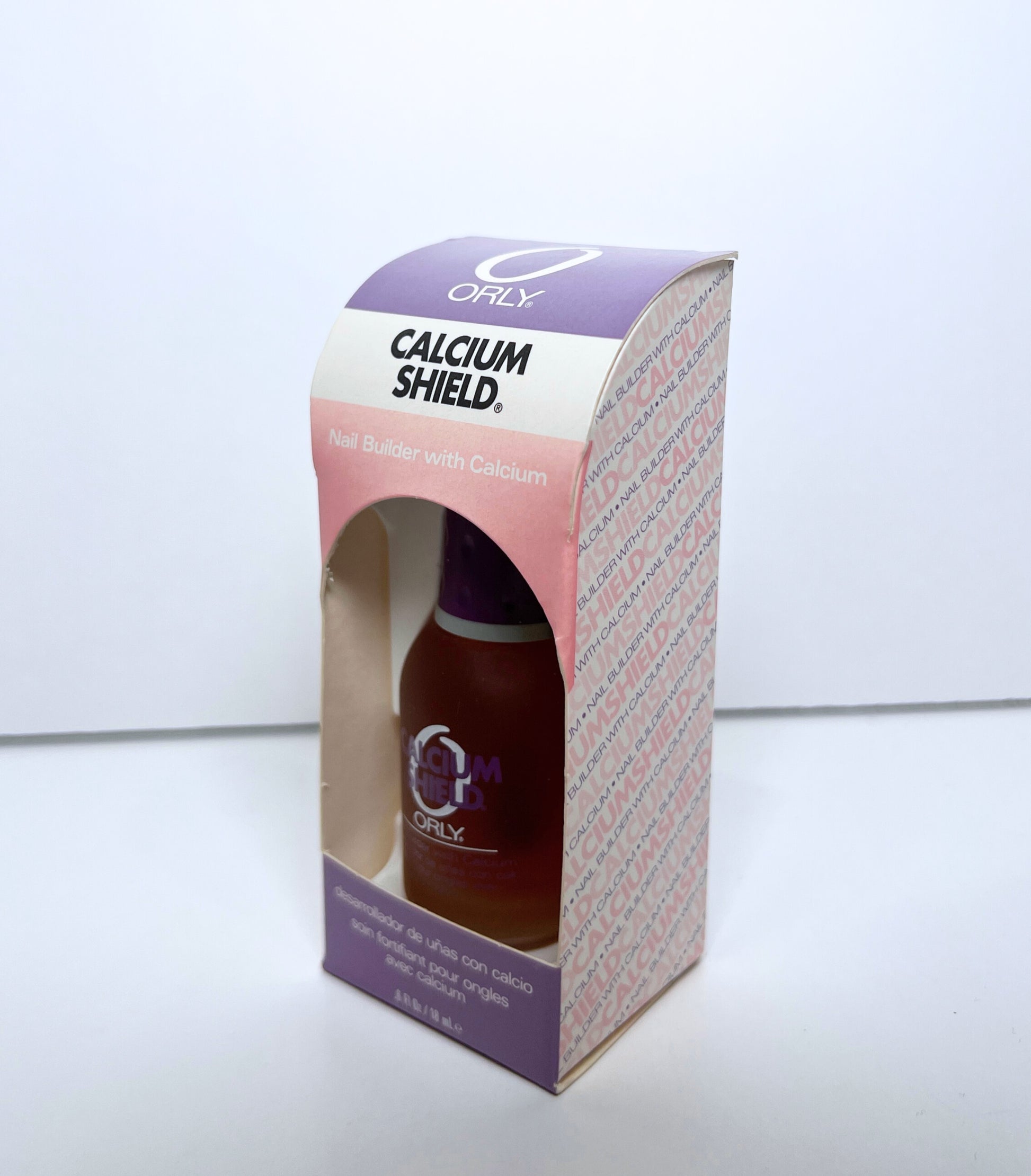 nail polish bottle inside purple and pink colored paper box on a white background