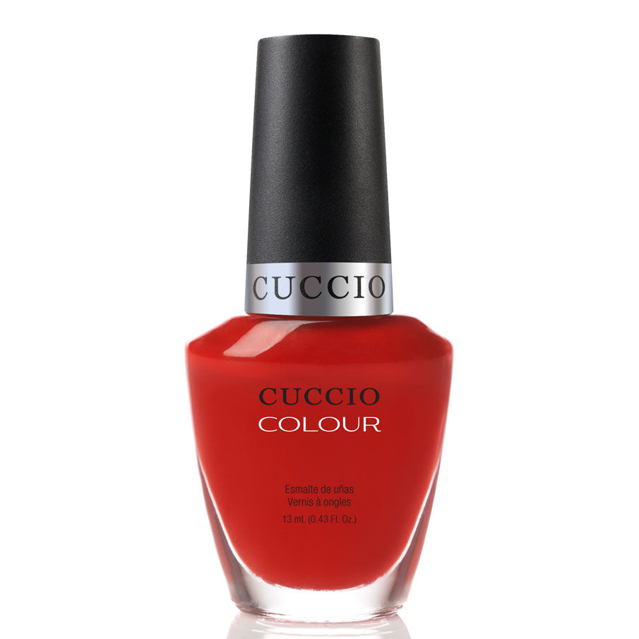 Red nail polish bottle with black cap on a white background