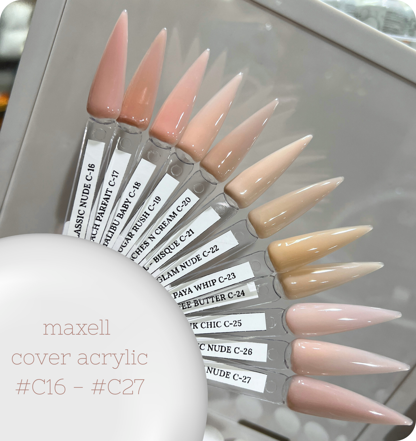 Maxell cover acrylic nail samples in various shades on a stand.