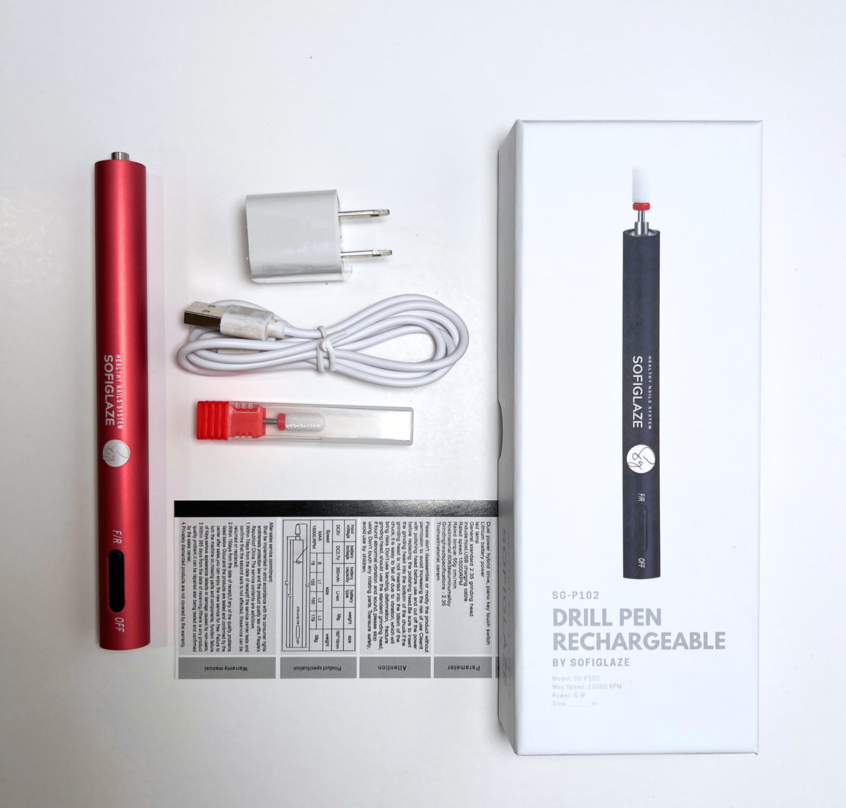 nail drill, drill bit, adapter, USB cable, instruction manual and box with an image of nail drill on it all over a white background